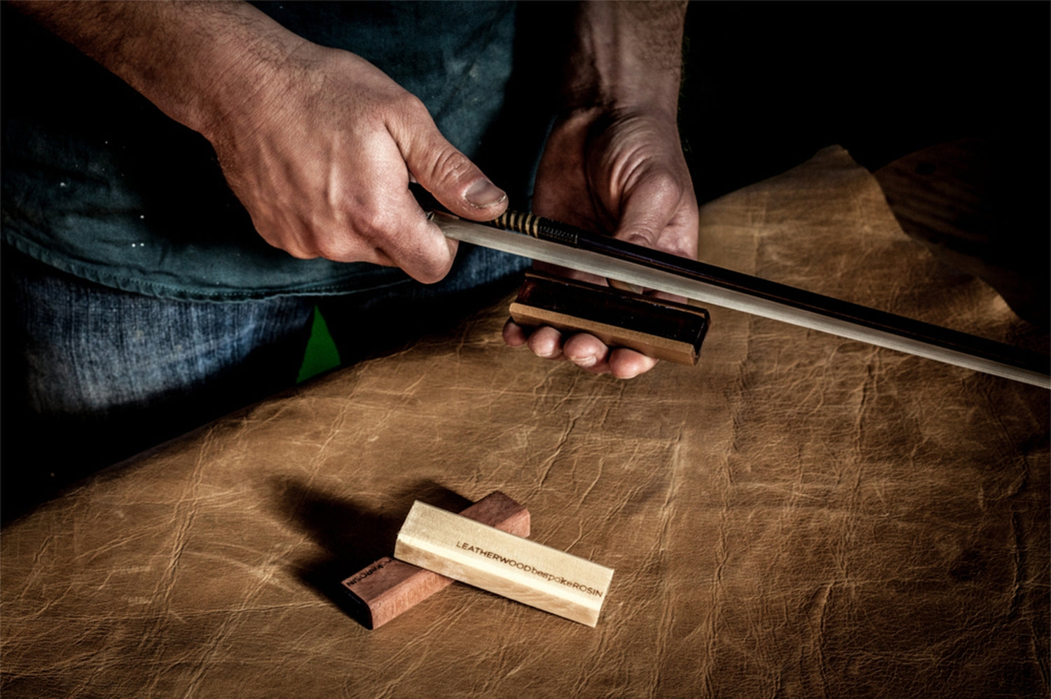 Person working on a leatherwood item with tools on a leather surface